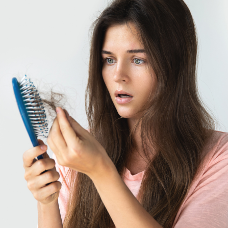 Une femme stupéfaite retire tous les cheveux pris dans sa brosse