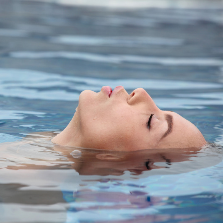 Une femme est en train de se relaxation dans la mer, seul son visage est hors de l'eau
