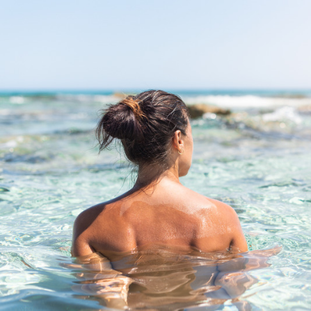 Une femme se baigne dans l'eau de la mer