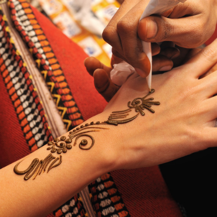 Réalisation d'un tatouage au henné sur la main