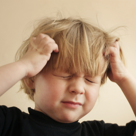 Un enfant se gratte la tête