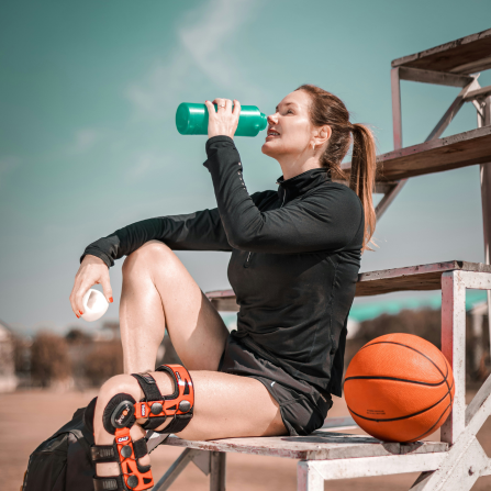 Femme sportive consommant une boisson isotonique pour rester hydratée et maintenir ses performances.