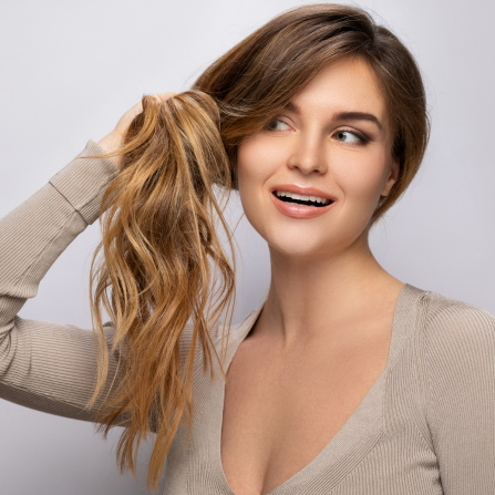 Une femme tient ses cheveux longs dans ses mains