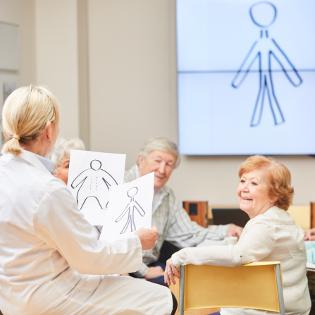 Une médecin est face à un groupe de personnes âgées