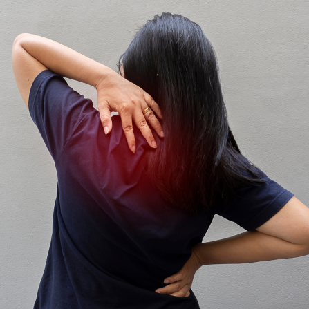 Une femme souffre de douleurs musculaires dans le haut du dos
