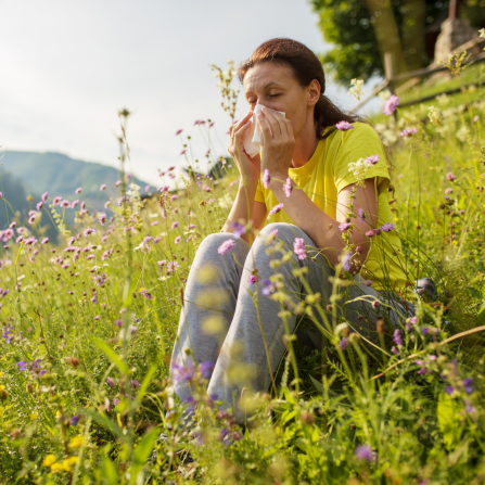 Une femme allergique se mouche dans l'herbe