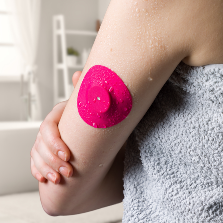 Une femme porte un patch Capteur Protect de couleur rose, même sous l'eau