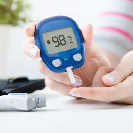 Une femme utilise un glucomètre pour mesurer son taux de glucose