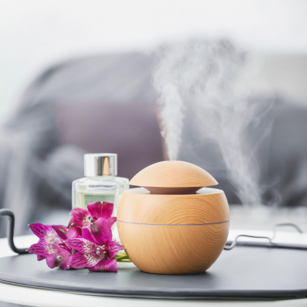 Un diffuseur est posé sur un plateau et diffuse des huiles essentielles dans un salon