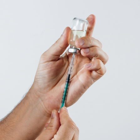Un homme remplit une seringue dans un flacon d'insuline