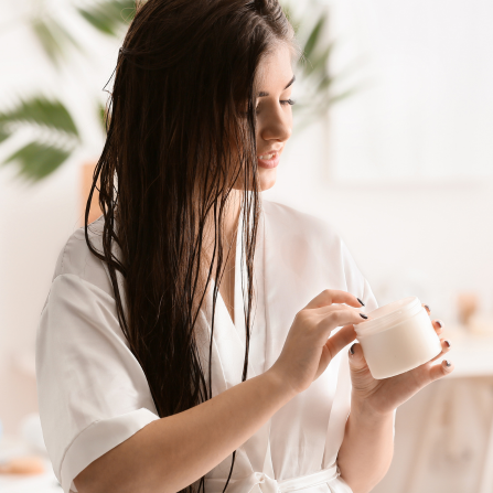 Une femme applique un masque capillaire sur ses cheveux