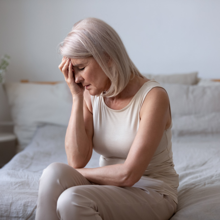 Une femme souffrant de migraine pose la main sur son front