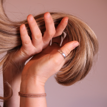 Une femme tient ses cheveux entre ses mains
