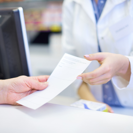 Un patient tend une ordonnance à un pharmacien