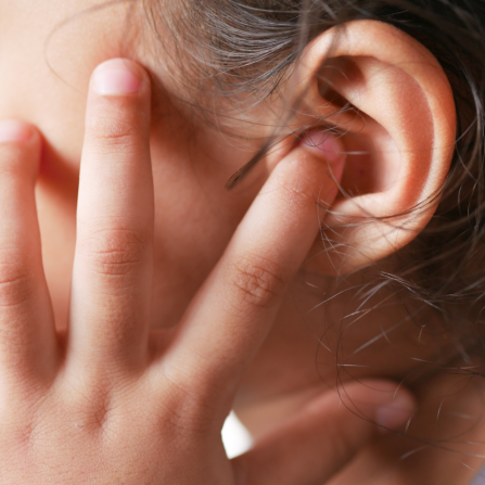 Une petite fille se touche l'oreille