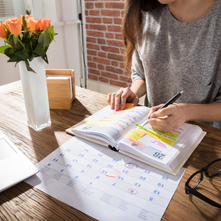 Une femme tient un agenda pour s'organiser au quotidien