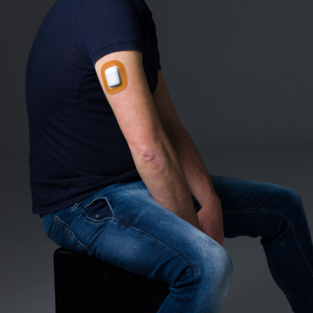 Un homme porte un patch capteur protect de couleur marron sur sa pompe à insuline