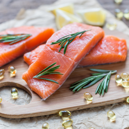 Des compléments alimentaires sont disposés près de tranches de saumon riches en oméga 3
