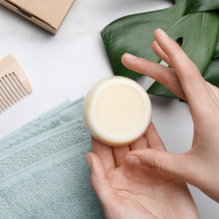 Un femme tient un shampoing solide entre ses mains