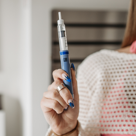Une femme tient un stylo à insuline