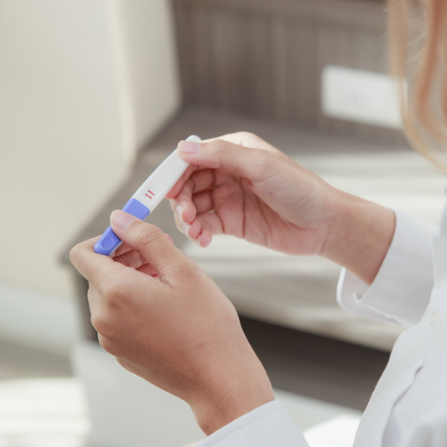 Une femme tient un test d'ovulation positif 