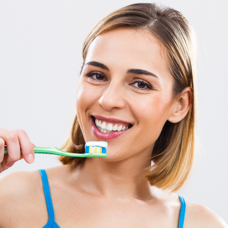 Femme souriante qui se brosse les dents 
