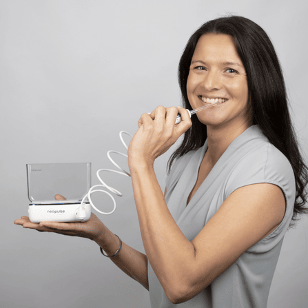 Une femme utilise le jet dentaire NP1 Micro de Neopulse